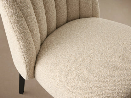 Arco Channel Dining Chair with textured cream upholstery, rounded backrest, elegant vertical channels, and dark tapered legs.