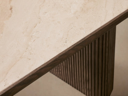 Astor Dining Table: Oval light marble top on two dark brown reeded oak pedestal bases against a beige wall and wood floor.
