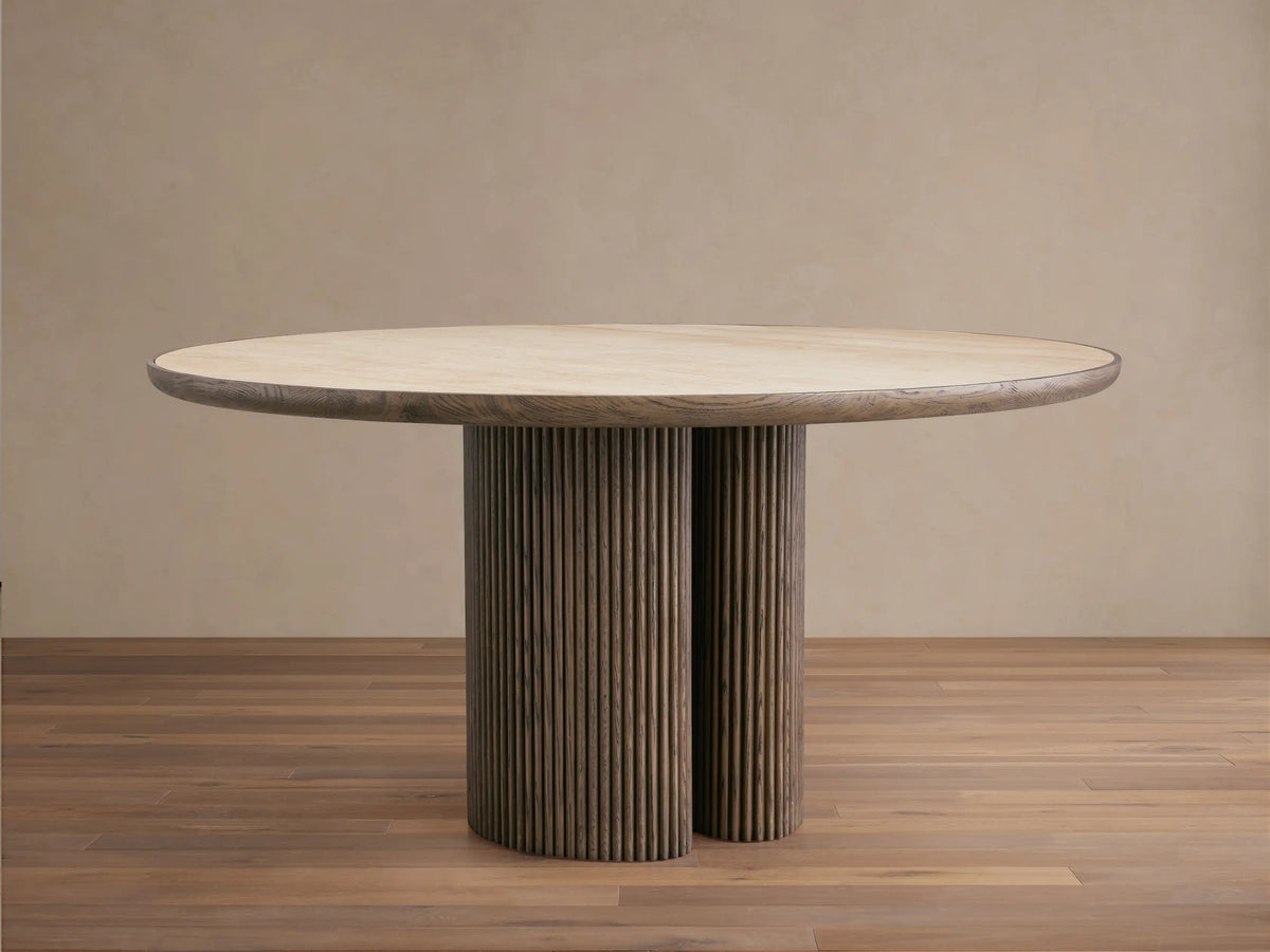 Astor Round Dining Table: Light marble top, two dark oak reeded cylindrical bases, angled on a wooden floor.