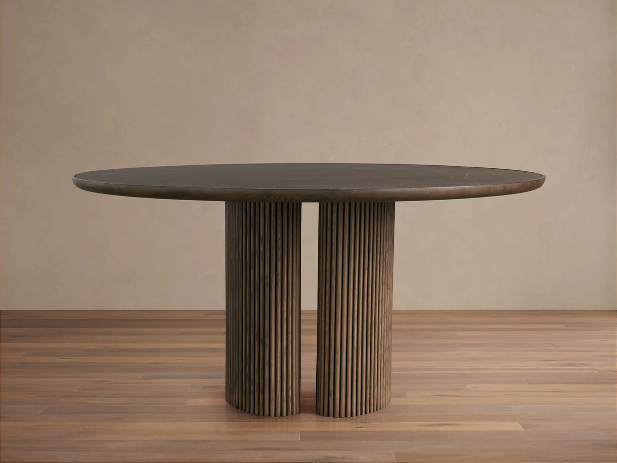 Astor Round Dining Table with oak veneer top, reeded solid oak base, and inset natural marble accents on a wooden floor.