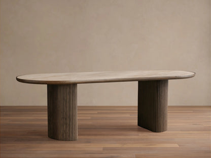 Astor Dining Table: Oval light oak veneer top with dark trim, two dark reeded cylindrical oak bases, front view on wood floor.