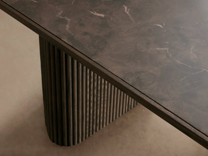 Astor Dining Table in oak with solid reeding detailing. Oval top with inset natural marble, two ribbed column supports, set on wooden floor.