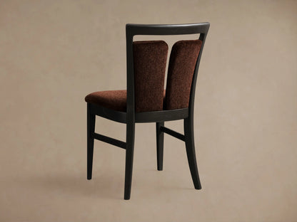 Close-up of the rust brown upholstered Beatrice Dining Side Chair, showing its dark wood split-back frame, angled.