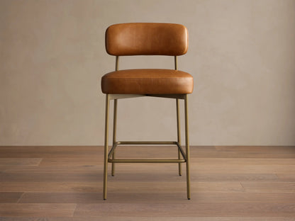 Front view of the brown Billie Stool in Faux Leather, featuring a padded seat and backrest, on an antiqued iron frame.
