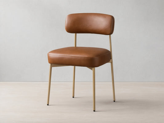 Front view of the brown faux leather Billie Dining Chair with gold-toned metal legs and a padded seat.