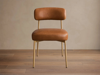 Rear view of the brown Billie Dining Chair in Faux Leather with padded seat and back, and an antiqued gold iron frame.