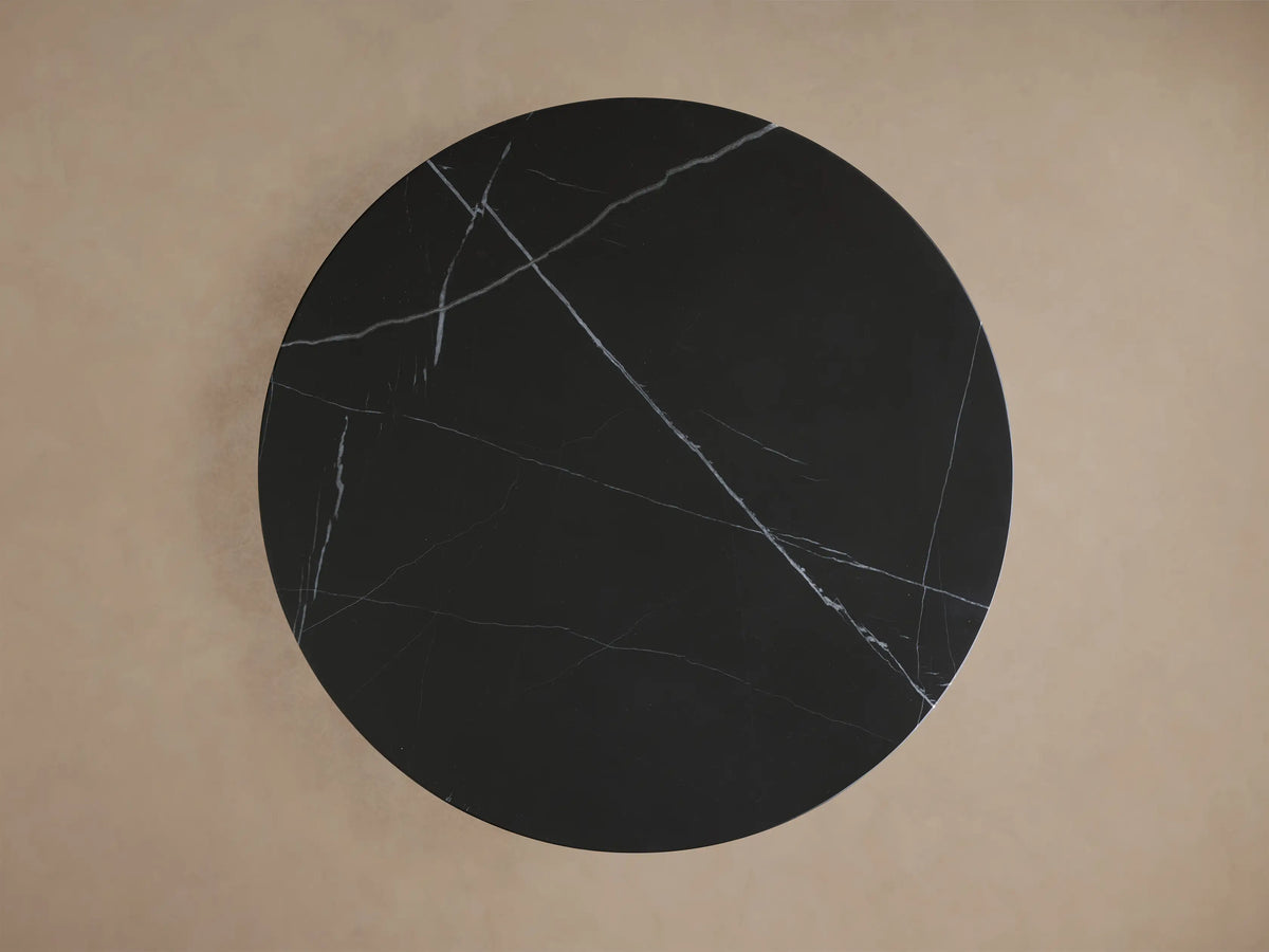 Overhead view of the black stone Saint Germain Bar Table's round tabletop featuring intricate white natural veining.