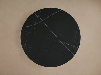 Black marble Saint Germain Counter Table with light veining, round top, and gold-toned steel base on a neutral background.