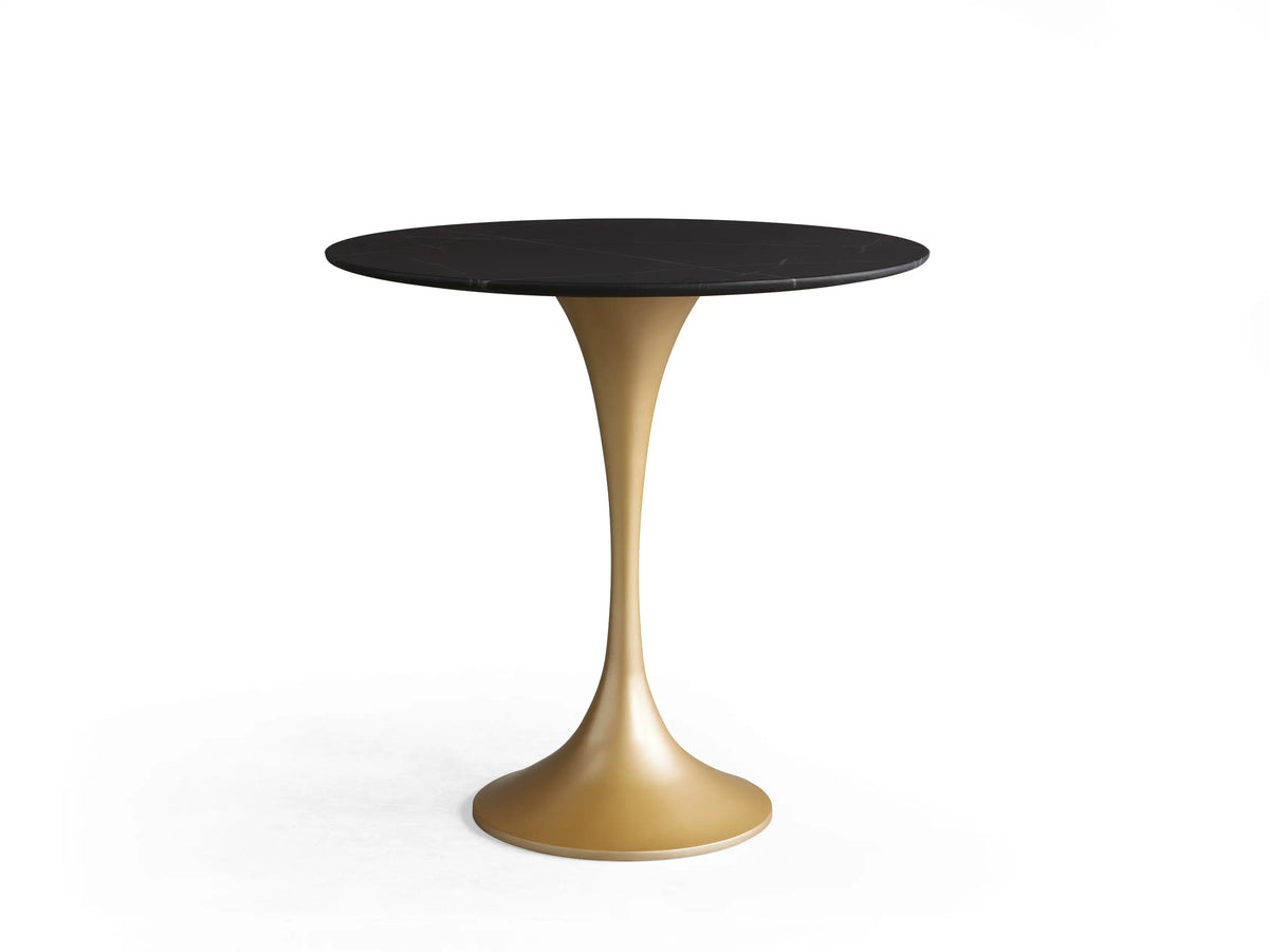 Saint Germain Bistro Table with a round black tabletop and a sleek, golden steel base on a wooden floor background.