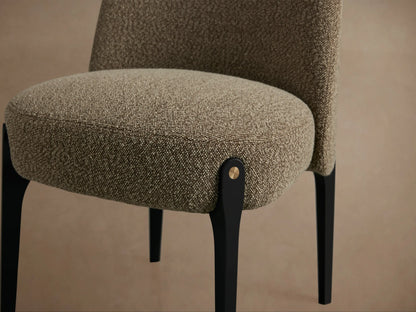 Bottoni Dining Chair, front view. Curved upholstered back and seat in textured brown fabric. Tapered black legs, brass accents.