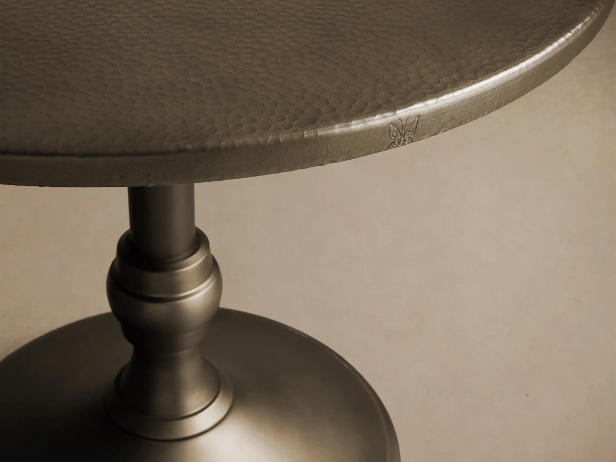 Front view of a brass-finished Recycled Metal Bistro Table with Wade Base, featuring a round top and flared pedestal base.