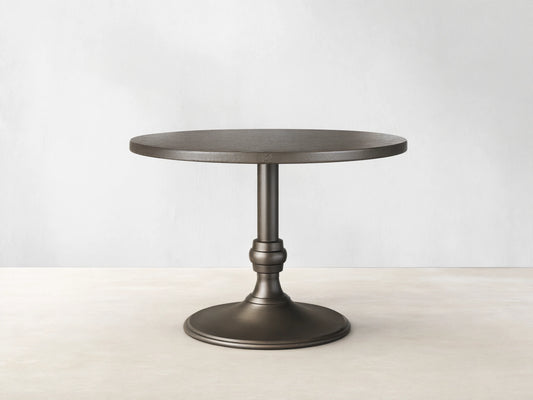 Front view of a brass-finished Recycled Metal Bistro Table with Wade Base, featuring a round top and flared pedestal base.