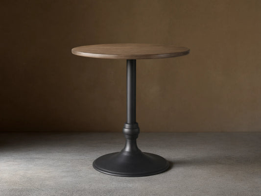Recycled Metal Counter Table with a round, dark metallic top and a matte black Wade pedestal base on a wood floor.