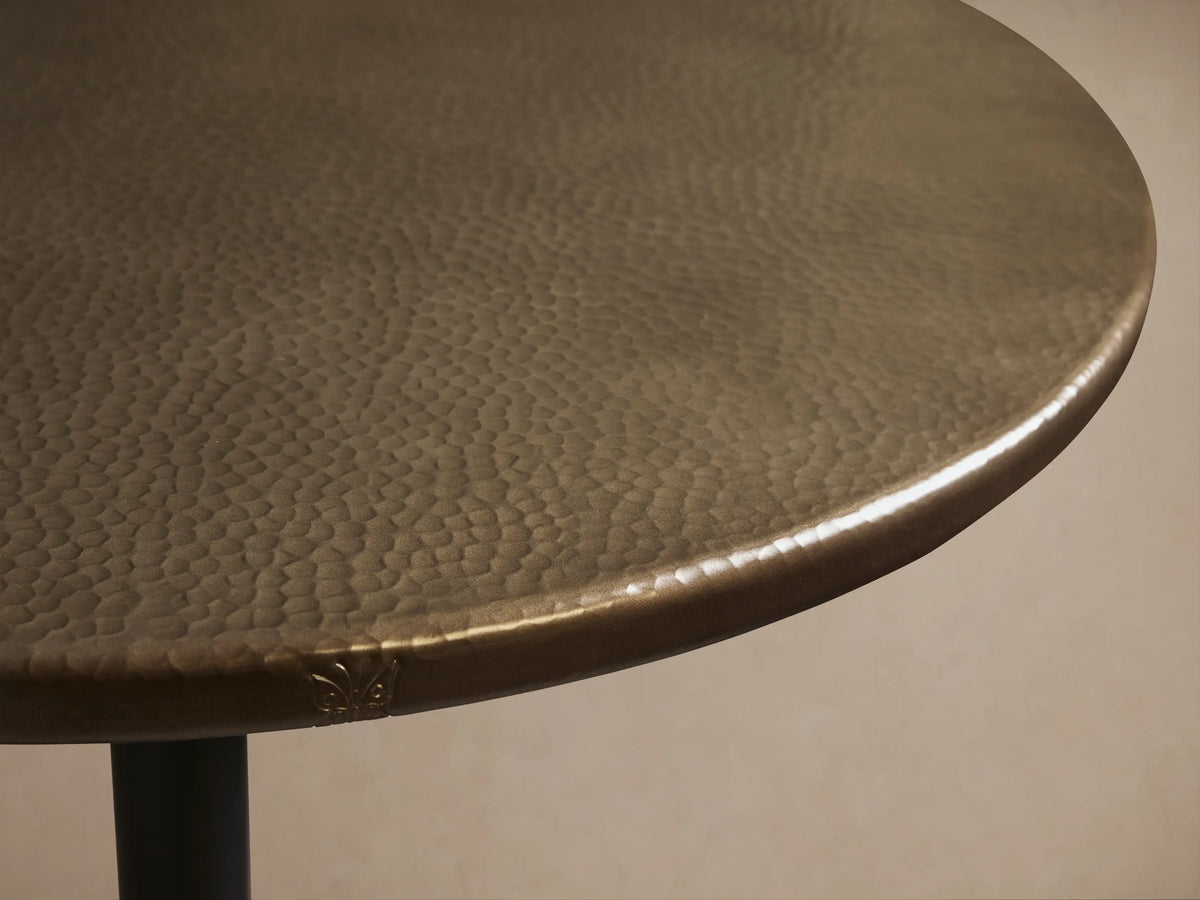 Recycled Metal Counter Table with a round, dark metallic top and a matte black Wade pedestal base on a wood floor.
