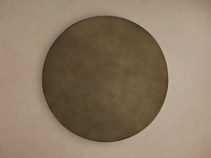 Recycled Metal Bar Table, close-up of round, hammered brass-finished tabletop. Textured surface reflects light, showing intricate detail.