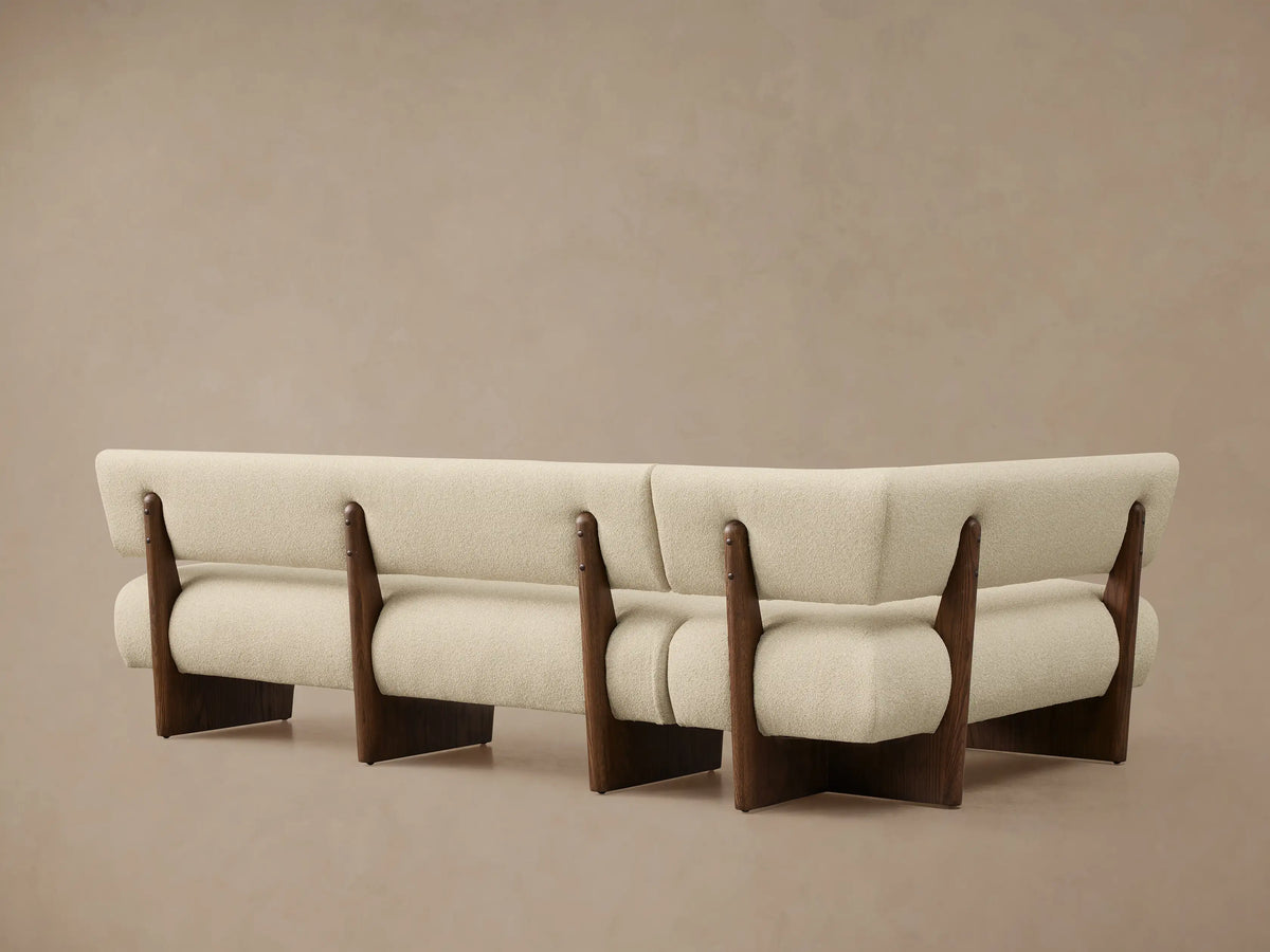 Light cream textured Beau Banquette with a dark oak veneer frame, showing its curved backrest and seat.