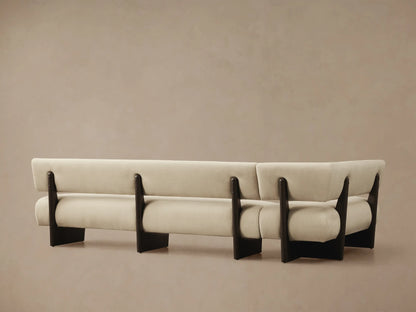 Beau Banquette close-up, showing light beige textured upholstery on the back and arm, with a dark exposed wood frame detail.