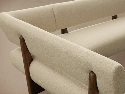Beau Banquette: Modern L-shaped banquette with light cream textured upholstery, supported by a dark wood frame. Viewed on wood floor.
