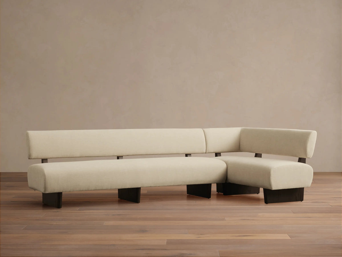 Beau Banquette: L-shaped, minimalist sofa with low back, light beige upholstery, and dark brown frame on wood floor.