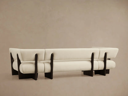 Beau U-Shaped Banquette corner, angled. Cream textured fabric upholstery with rounded cushions and dark wood frame details.