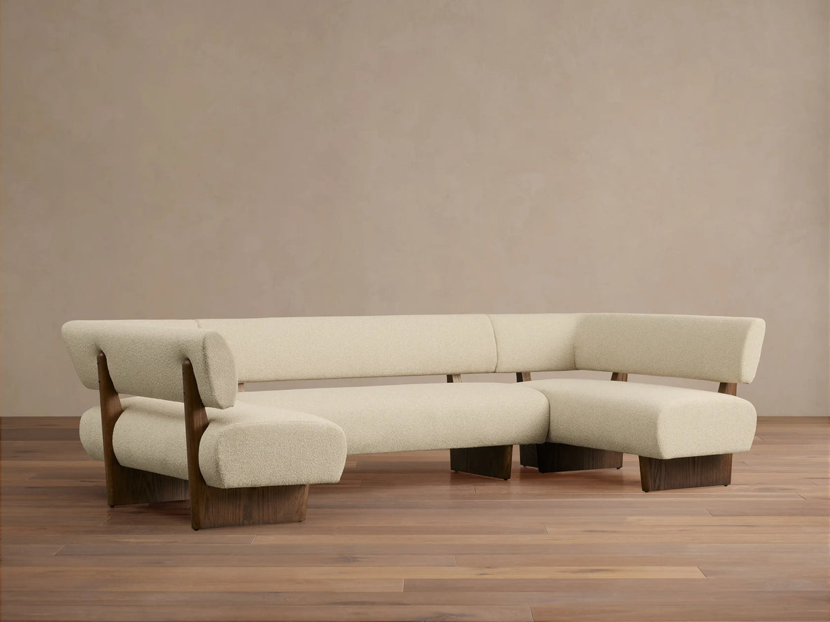 Beau U-Shaped Banquette. Cream textured upholstery, dark wood frame & base. Front view on wood floor.