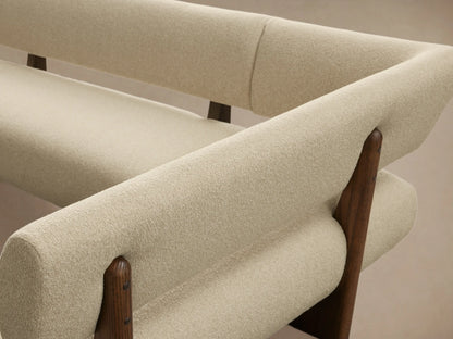 Beau U-Shaped Banquette, cream boucle upholstery with dark wood frames, on a light wooden floor against a beige wall.