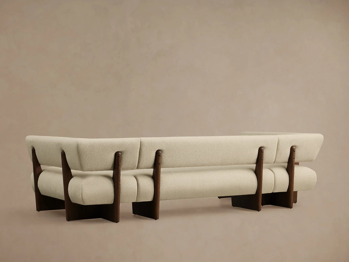 Beau U-Shaped Banquette with light beige textured upholstery and dark wood frame, showing a curved section.