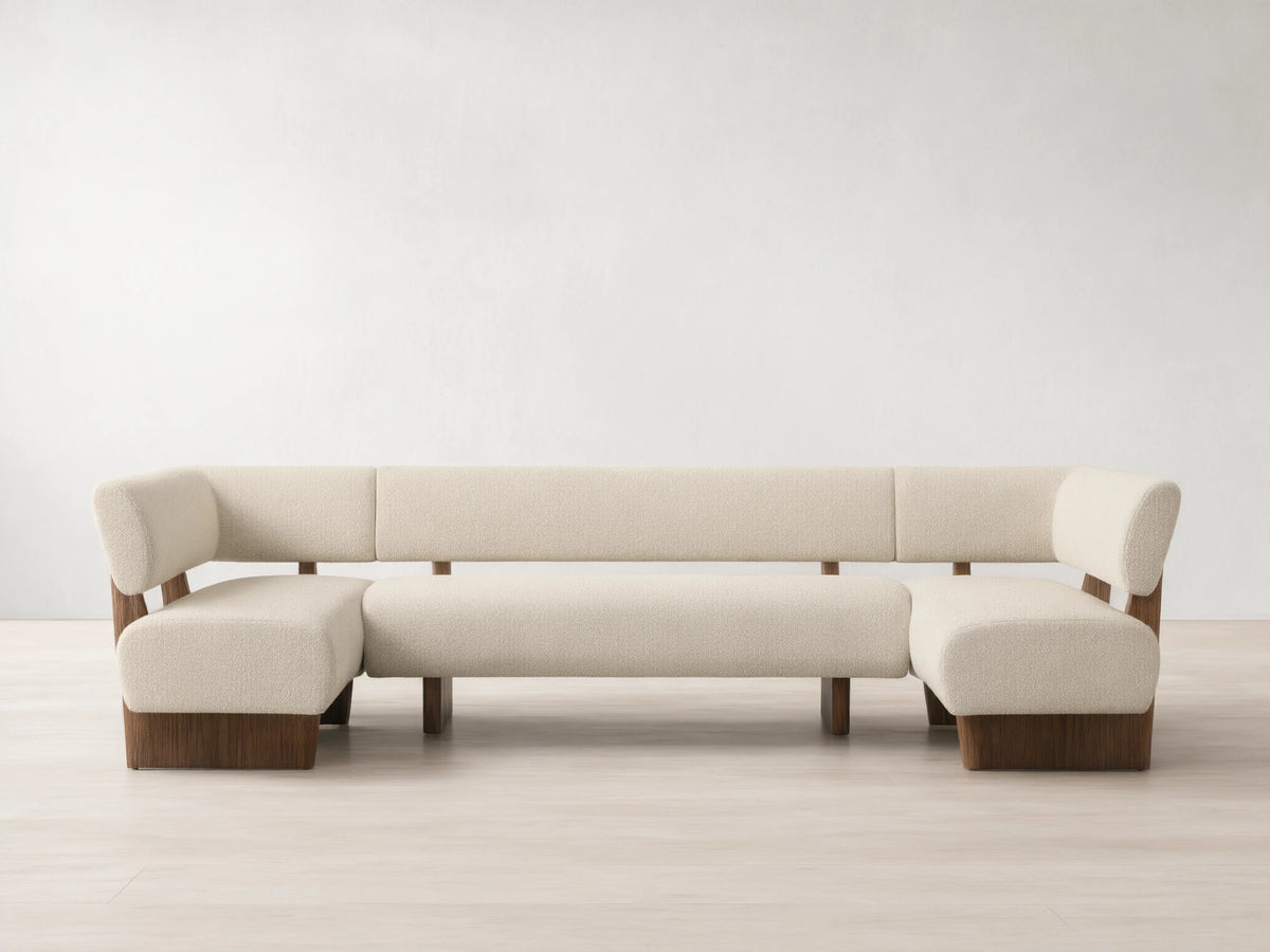 Beau U-Shaped Banquette. Cream textured upholstery, dark wood frame & base. Front view on wood floor.