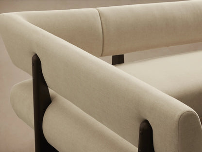 L-shaped cream Beau Banquette with dark exposed wood frame, against a plain wall on a hardwood floor.