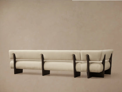 Angled close-up of Beau Banquette showing light beige fabric armrest curving over a dark wooden support, with seat & back.