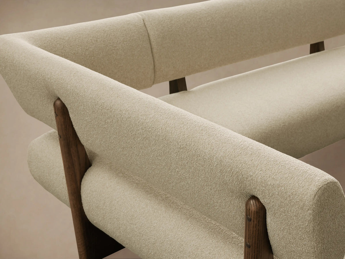 Beau Banquette: L-shaped, light beige textured fabric cushions, dark exposed wooden frame, on a warm wooden floor.
