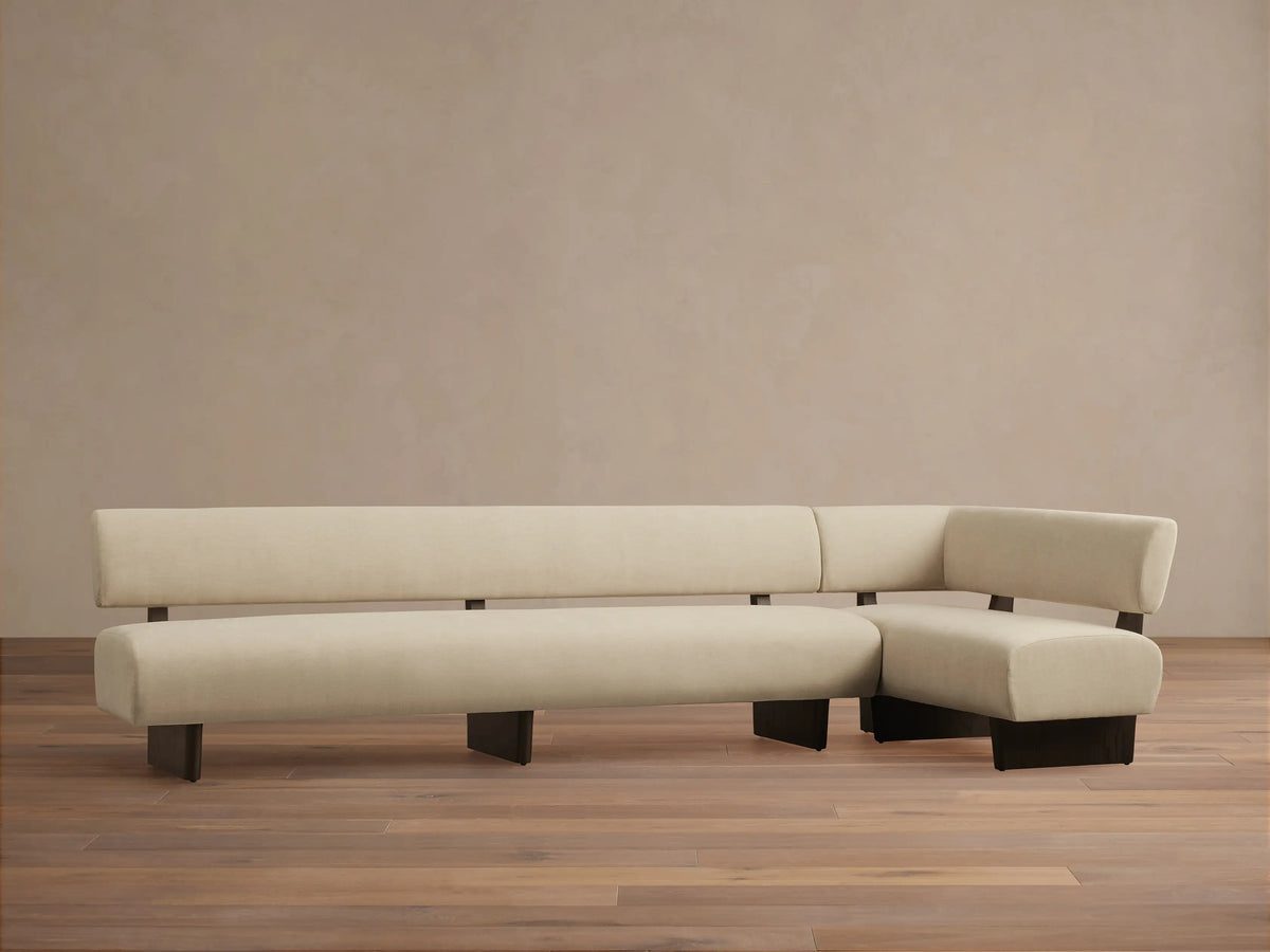 Beau Banquette: modern L-shaped sofa in cream upholstery with a dark wooden exposed frame, on a wooden floor.