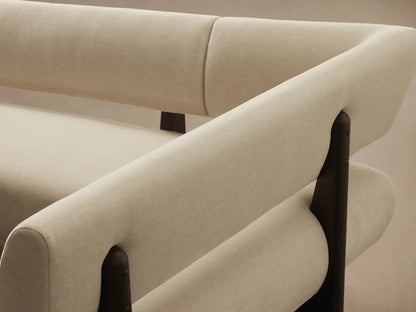 Beau Banquette, L-shaped, light cream upholstered, dark wood frame & legs, on a wood floor.