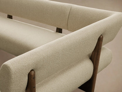 Beau Banquette: L-shaped sofa with textured cream cushions and dark wood base, angled on a wooden floor.
