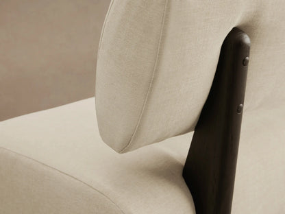 Beau Banquette: Long, modern cream upholstered bench with a rounded backrest, supported by dark, flat legs on wood floor.