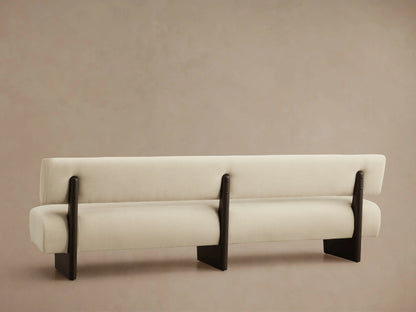 Close-up of Beau Banquette's light beige fabric seat and dark wood back support with subtle metal accents.