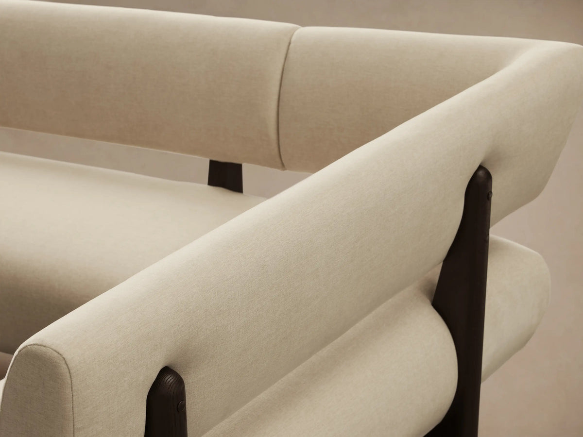 Light beige Beau U-Shaped Banquette with dark wood frame, against a light wall on a wooden floor.