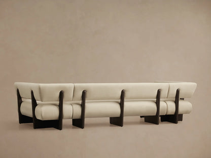 Close-up of Beau U-Shaped Banquette corner. Light beige fabric upholstery with dark brown exposed wood frame.
