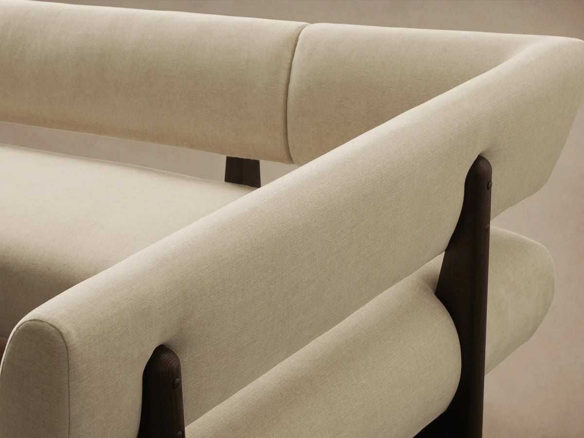 Beau U-Shaped Banquette with light beige upholstery and dark brown exposed wood frame and base, viewed head-on on a wood floor.