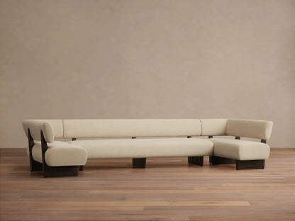 Beau U-Shaped Banquette, cream upholstery with dark wood frame, on a wooden floor against a light beige wall.