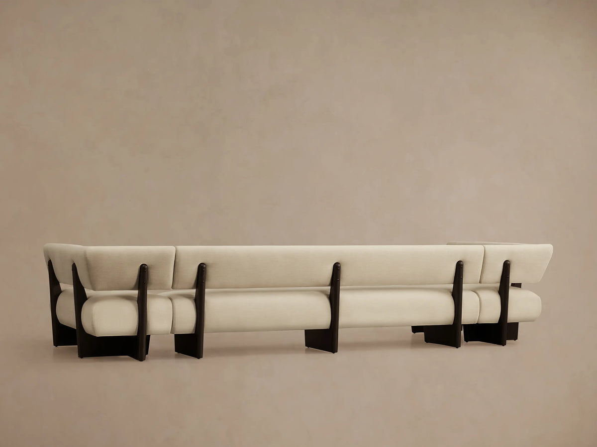 Beau U-Shaped Banquette, close-up of light cream upholstered armrest and backrest with dark brown wood frame.