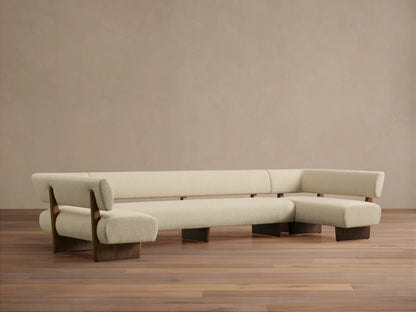 Beau U-Shaped Banquette with light cream upholstery, dark oak wood frame, sitting on a hardwood floor.