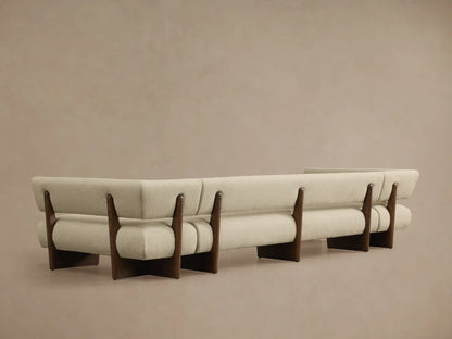 Beau U-Shaped Banquette. Close-up of light beige textured fabric and dark wood frame, showing a curved section and plush upholstery.