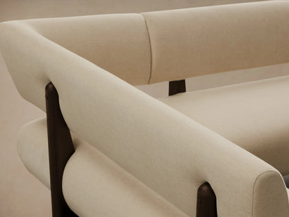 Light cream L-shaped Beau Banquette with dark exposed wood frame, on a wooden floor against a beige wall.
