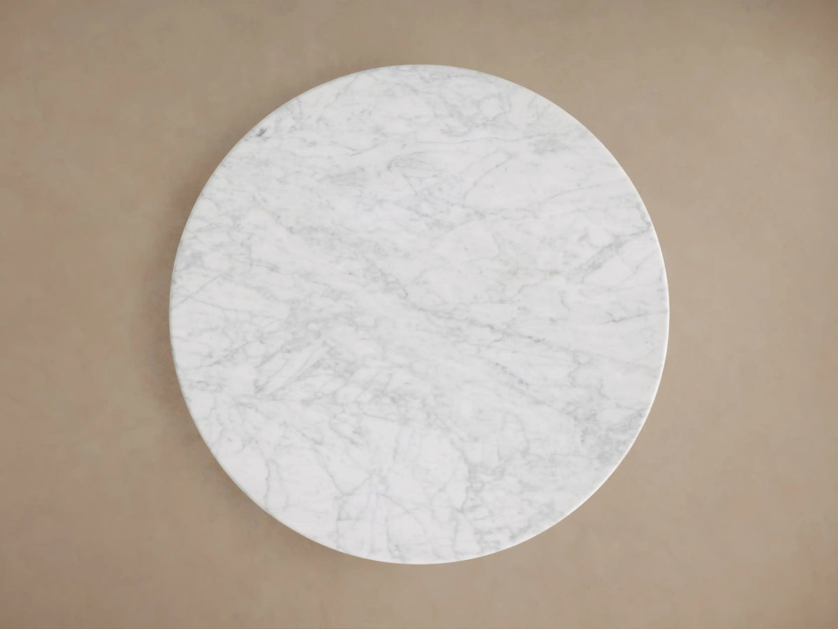 Saint Germain Bistro Table with round Carrara marble top, showing distinct veining, above a gold steel base.