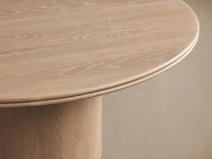 Caden Round Wood Dining Table. Light, sand-finish oak veneer top and thick cylindrical base showing wood grain.
