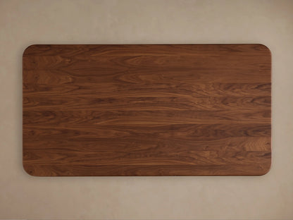 Caden Wood Dining Table: Close-up of its rounded, dark walnut wood top corner, showing rich grain and a smooth, sculpted edge.