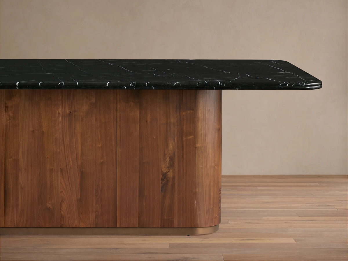 Caden Dining Table corner with a black Marquina stone top featuring white veining, supported by a walnut wood veneer base.