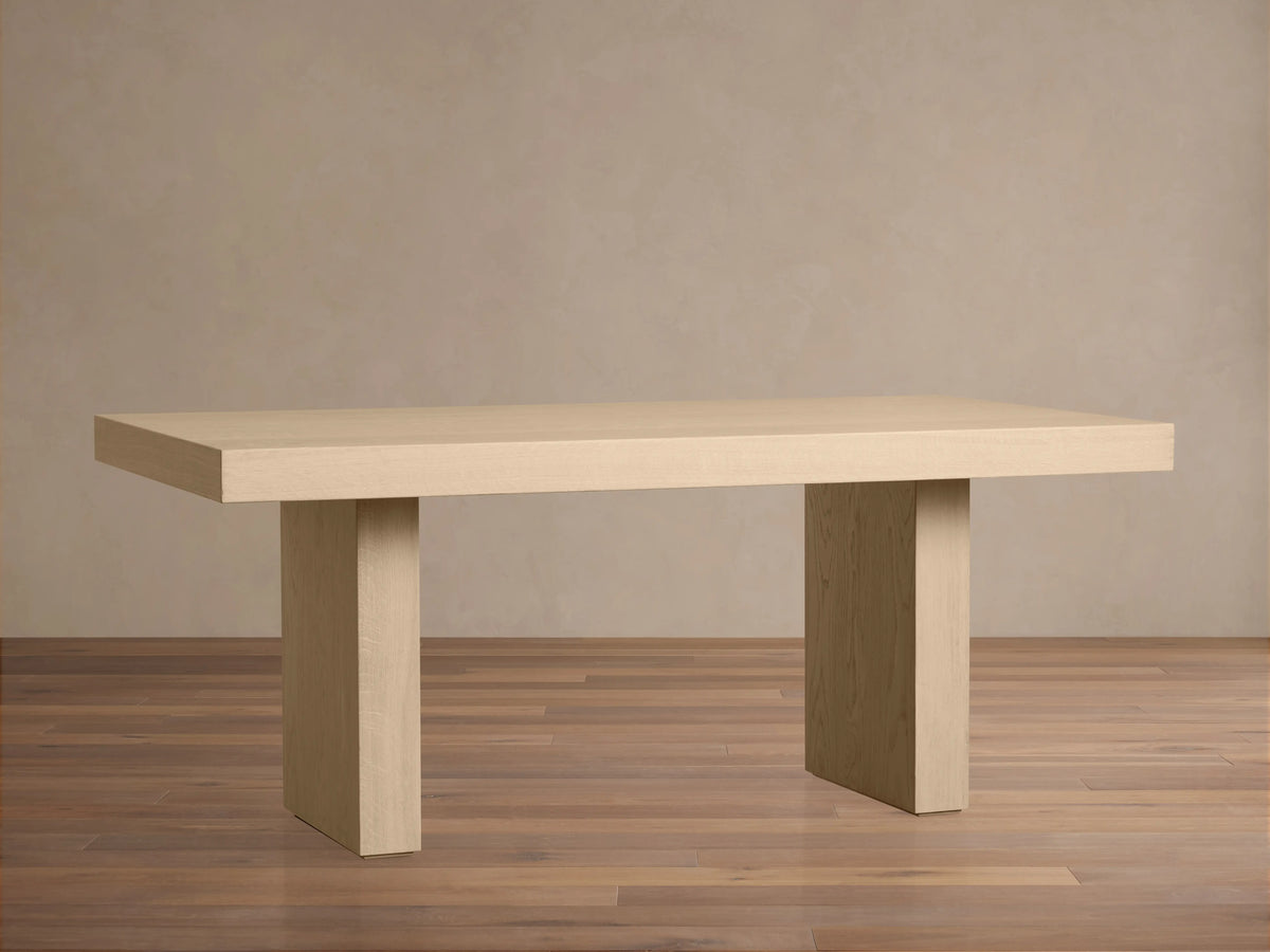 Close-up of the Calvin Dining Table's corner, highlighting light oak veneer wood grain on the top surface and thick edge.