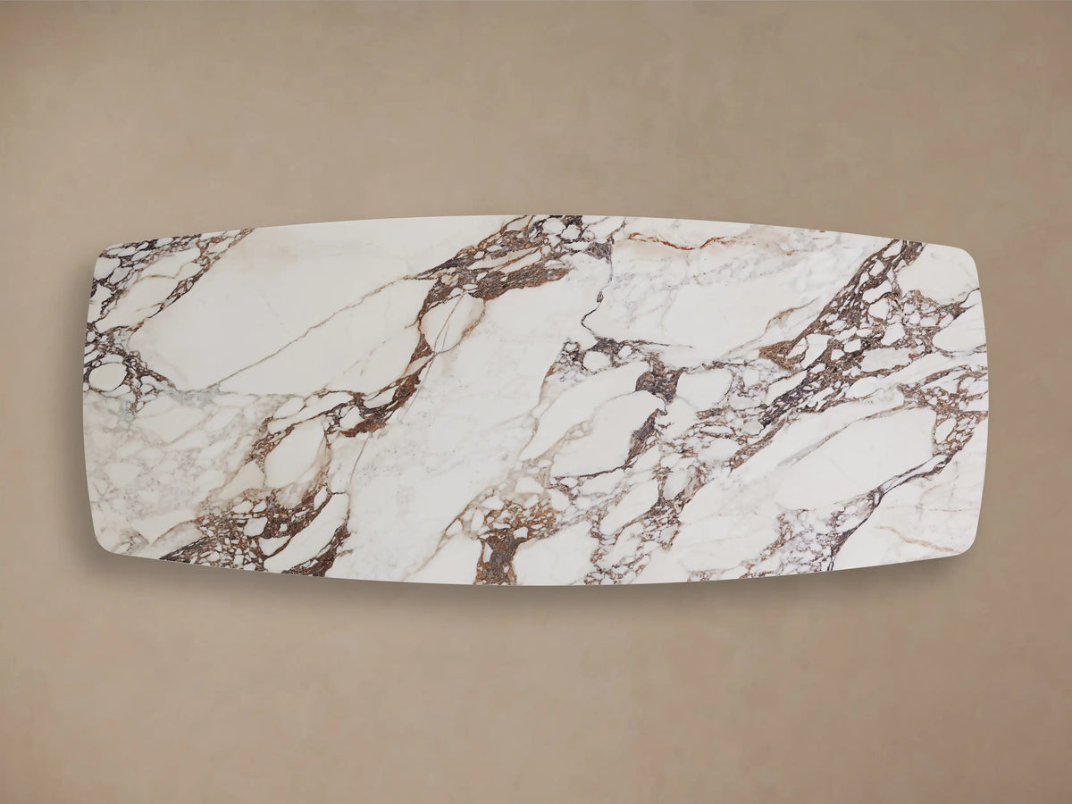 Vincenza Dining Table with Launette Base featuring a marble-patterned ceramic top and steel base with smooth curves.